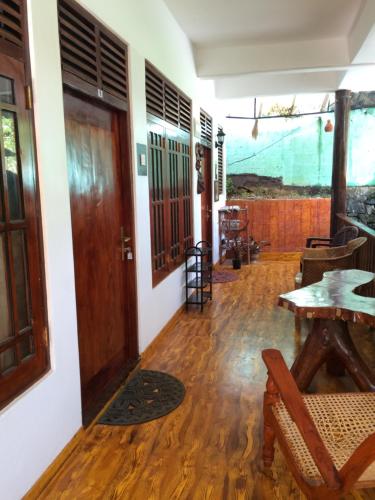 a room with a table and a wooden door at Eco Villa - Sinharaja in Deniyaya