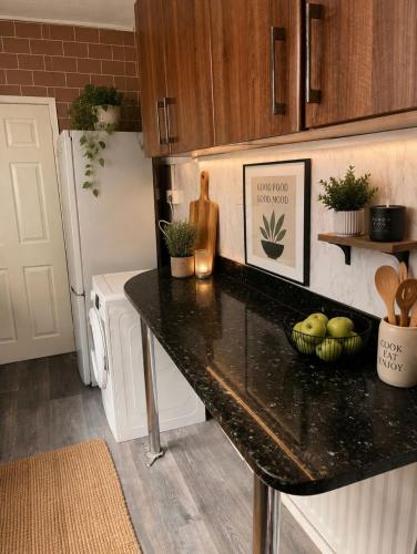 a kitchen with a black counter top and a refrigerator at Stylish Room in Wolverhampton opp Asda in Wolverhampton