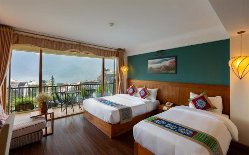 a hotel room with two beds and a balcony at Sapa Panorama Hotel in Sapa