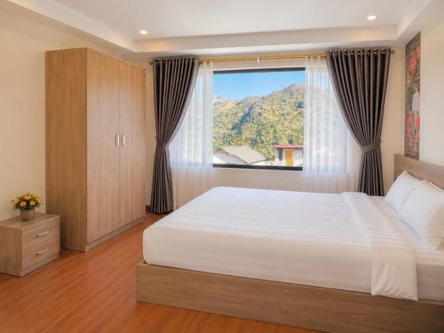 a bedroom with a large bed and a window at Cloud House Sapa in Sapa