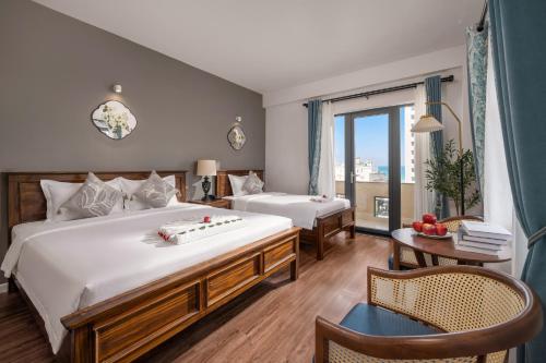 a hotel room with two beds and a balcony at KLY Hotel & Retreat in Vung Tau