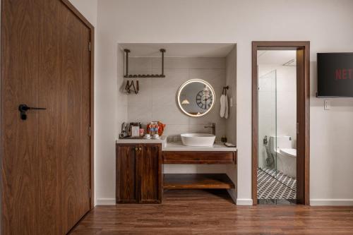 a bathroom with a sink and a tub and a mirror at KLY Hotel & Retreat in Vung Tau