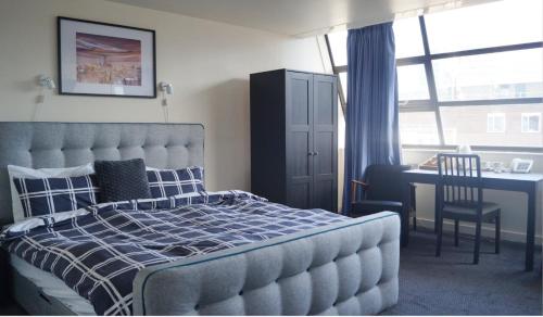 a bedroom with a bed and a desk and a table at YMCA Hotel in London