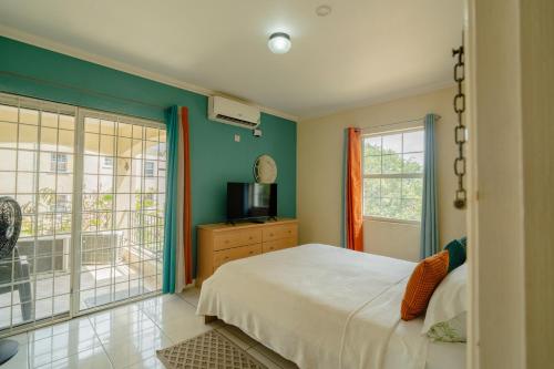 a bedroom with green walls and a bed and a television at Central 2 bed Apt near Devon House in Kingston