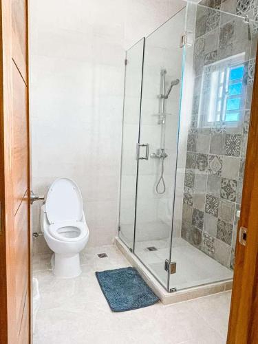 a bathroom with a toilet and a glass shower at Luxury Comfort Villa in Punta Cana