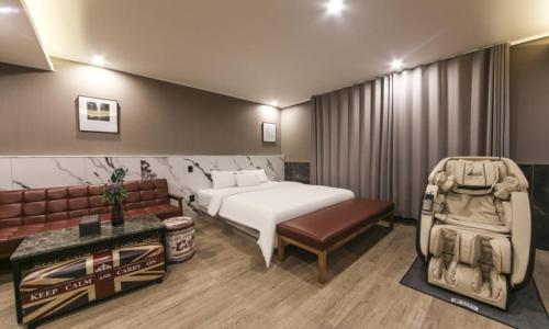 a hotel room with a bed and a couch at Daegu Seongseo Hotel Series 5.0 in Daegu