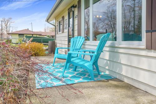two blue chairs sitting on the porch of a house at "At the Eau" - Charming 2 Bedroom Cottage! in Erieau