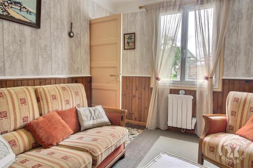 a living room with a couch and a window at Les papillons in Plérin