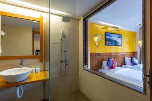 a bathroom with a shower and a sink and a bed at Sapa Panorama Hotel in Sapa