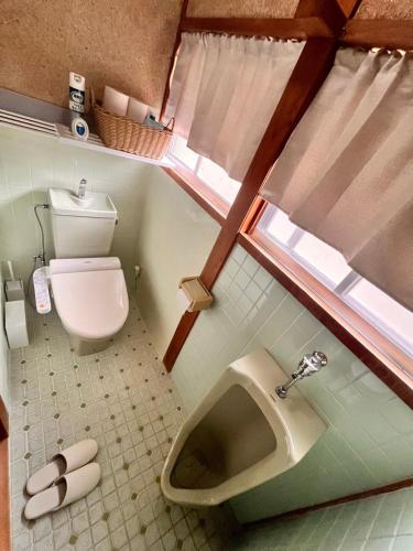 a small bathroom with a toilet and a sink at 城下の宿庵 in Ōzu