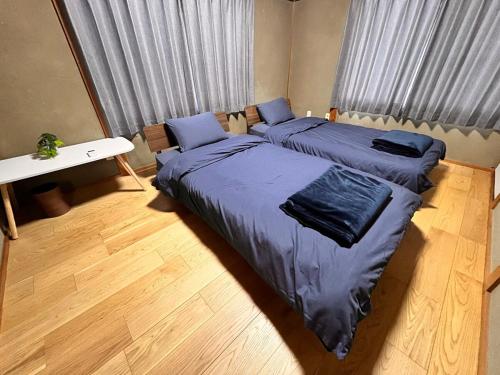 a bedroom with two beds with blue pillows at 城下の宿庵 in Ōzu
