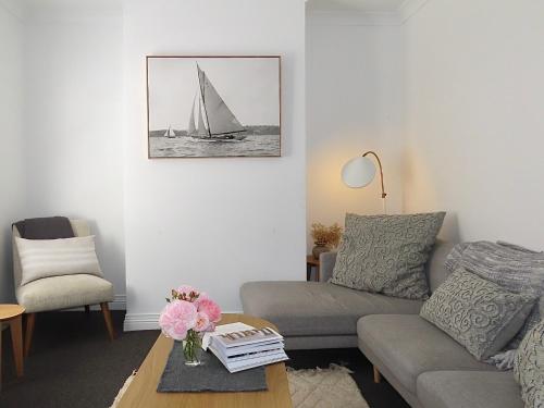 a living room with a couch and a sail boat at Tamara Cottage Historic Warmth in Hobart