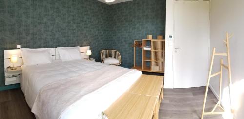 a bedroom with a large bed and a green wall at Le balcon des gorges in Saint-Rome-de-Dolan