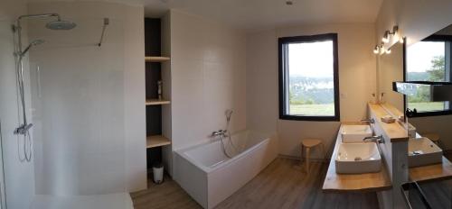 a bathroom with a tub and a sink and a bath tub at Le balcon des gorges in Saint-Rome-de-Dolan