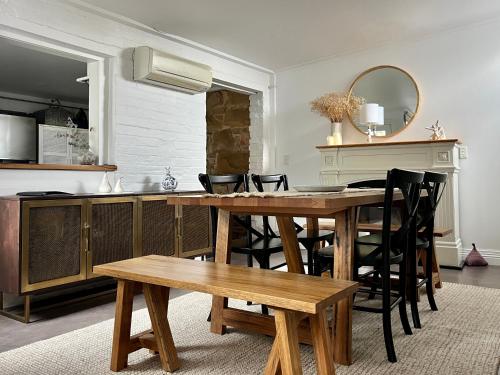 a kitchen with a wooden table with chairs and a counter at Tamara Cottage Historic Warmth in Hobart