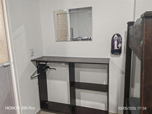 a bathroom vanity with a black counter and a mirror at Air b&b altos del peñon in Girardot