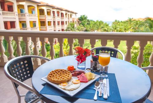 Infinity Bay Spa & Beach Resort في ويست باي: طاولة مع طعام الإفطار وكوب من عصير البرتقال