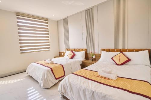 a bedroom with two beds and a window at La Mejor Homestay in Quang Tri