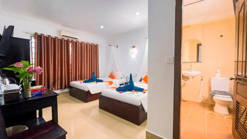 a hotel room with two beds and a sink at Harmony Hotel in Siem Reap