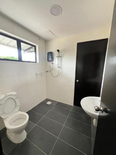 a bathroom with a toilet and a sink at JEC Suites in Kuching