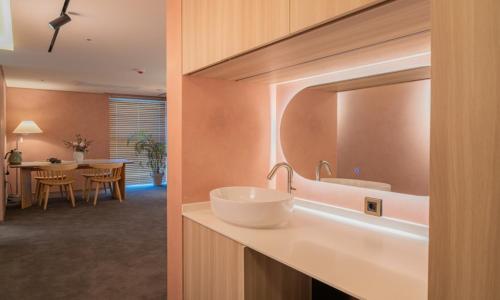 a bathroom with a sink and a mirror on a counter at Jamsil Orosie Hotel in Seoul