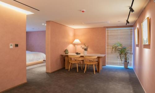 a room with a table and chairs and a bed at Jamsil Orosie Hotel in Seoul