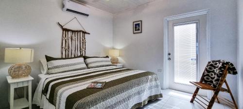 a bedroom with a bed and a chair and a window at Sand Star in Russel Island