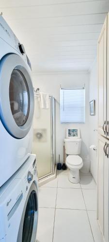 a washing machine in a bathroom with a toilet at Sand Star in Russel Island