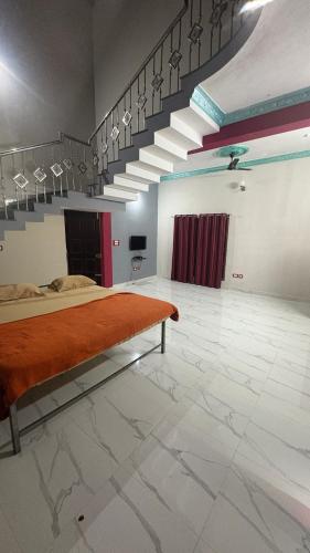 a large room with a bed and a staircase at Vanasiri stay inn in Sringeri