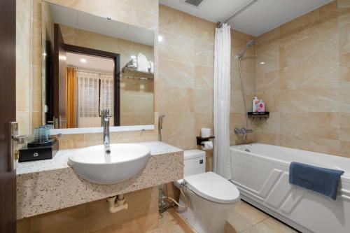 a bathroom with a sink and a toilet and a tub at Nagomi Residence in Hanoi