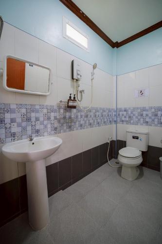 a bathroom with a sink and a toilet at Baanklongkok in Ban Map Khangkhao