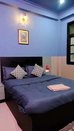 a blue bedroom with a large bed with purple sheets at Quiet Corner 4BHK Villa in Lucknow