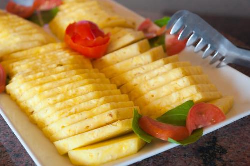 a plate of food with bananas and tomatoes and a fork at Infinity Bay Spa & Beach Resort in West Bay