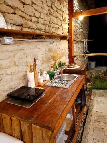 a kitchen with a sink and a stone wall at Emena Art Guesthouse in Emen