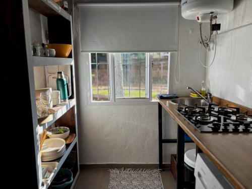 a small kitchen with a stove and a window at La Alpina playa Nebel in Concordia