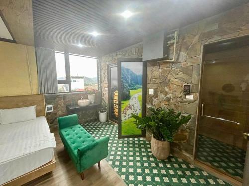 a bedroom with a bed and a stone wall at Khách Sạn Phố Cổ Ninh Bình NANA HOTEL in Kỳ Vĩ