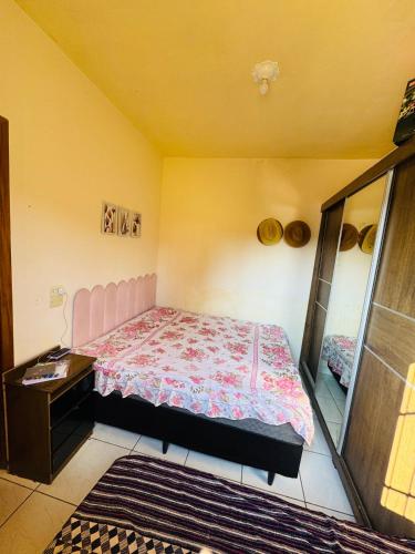 a small bedroom with a bed and a dresser at Chácara Nunes in Ibiúna