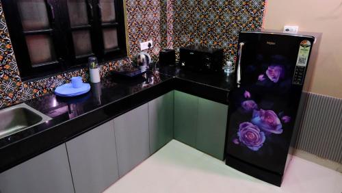 a kitchen with a refrigerator with flowers painted on it at Quiet Corner 4BHK Villa in Lucknow