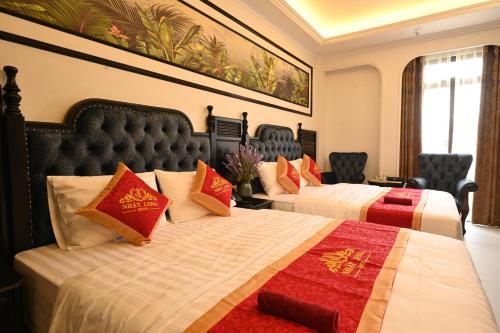 two beds in a hotel room with red and orange pillows at Nhật Long Hotel in Giap Ninh Binh