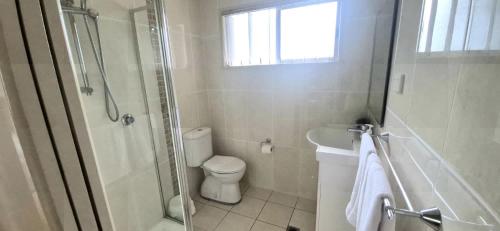 a bathroom with a toilet and a shower and a sink at Little Sanctuary by Book Jervis Bay - Your Perfect Getaway, A Short Stroll to Palm Beach in Sanctuary Point