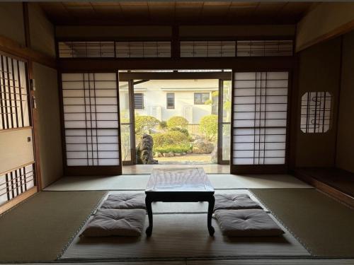 a room with a table in front of a door at Yoike Stay in Yonago
