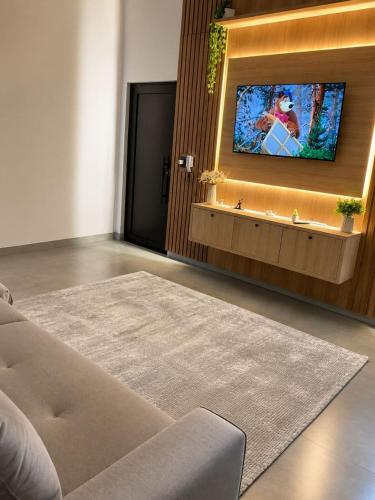 a living room with a flat screen tv on a wall at Casa Premium NOVA - Perto do Shopping em SINOP in Sinop