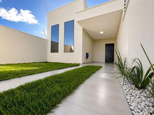 a modern home with a walkway and grass at Casa Premium NOVA - Perto do Shopping em SINOP in Sinop