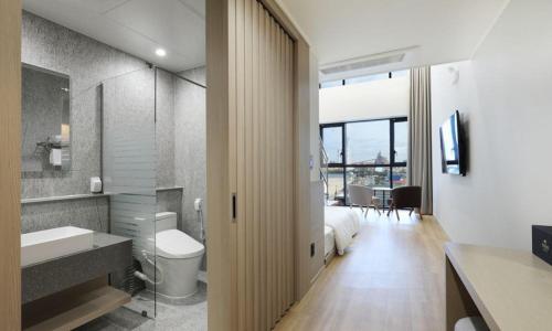 a bathroom with a bed and a sink and a toilet at Pohang Hound Hotel Songdo Beach in Pohang