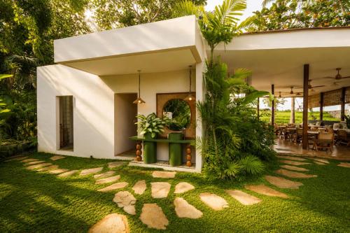 a house with a green yard with a patio at Loku Kedungu - Boutique Resort in Tanah Lot