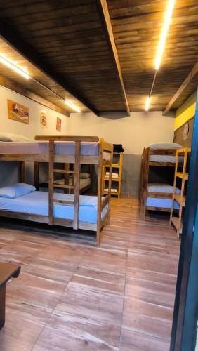 a room with several bunk beds and a table at Hostel y Motoposada Sudaka in Garupá