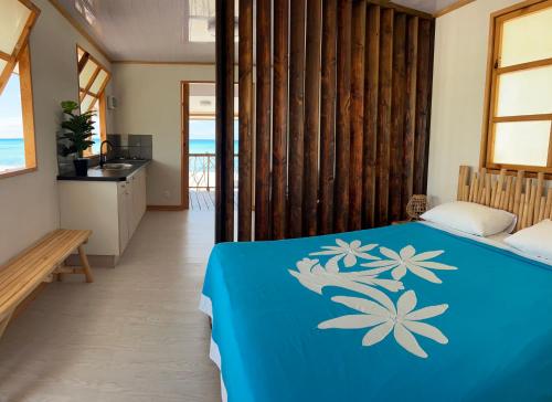 a bedroom with a blue bed with flowers on it at Hakamanu Lodge in Tikehau