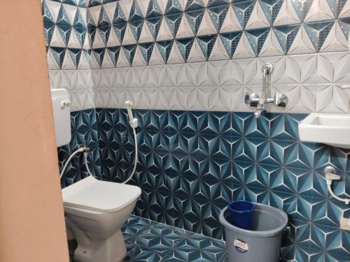 a blue and white bathroom with a toilet and a sink at Auro Delight - Near Auroville in Pondicherry in Villupuram