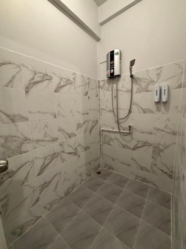 a bathroom with a shower with marble tiles at The Layover Donmueang Airport Hostel in Thung Si Kan