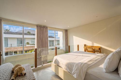 a bedroom with a bed and a large window at Villa Pia Pererenan in Cemagi
